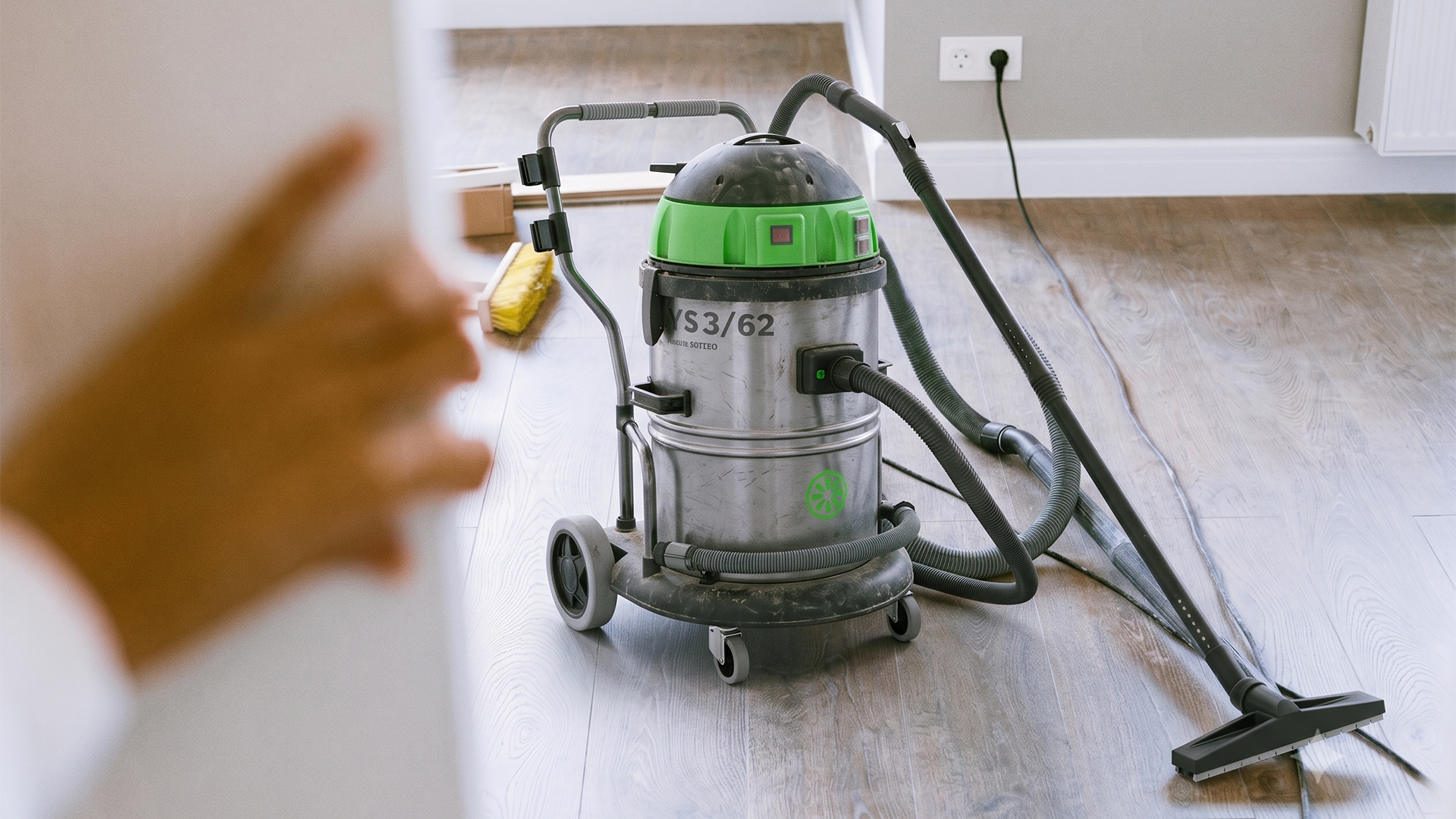 Agent d'entretien diagnostiquant un aspirateur professionnel en panne